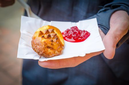 Traditional Polish street food in Zakopane, Europe. Smoked cheese with jam in a hand.
