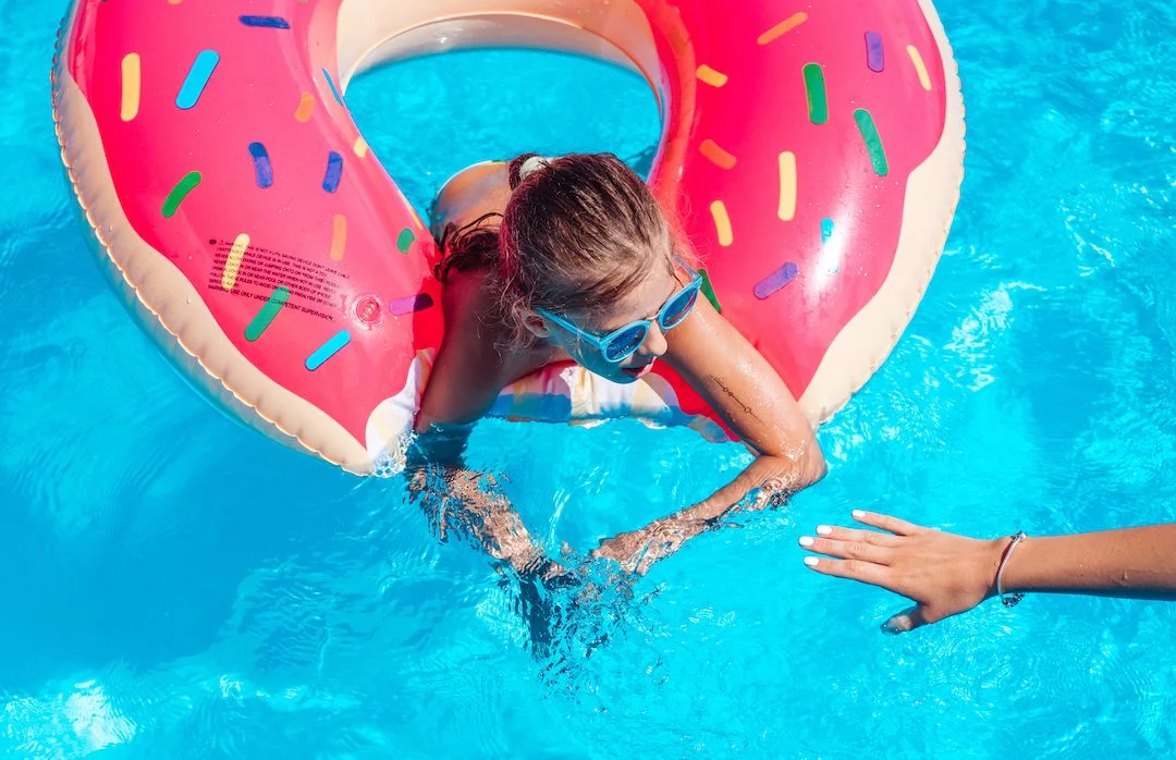 Girl on inflatable ring in swimming pool