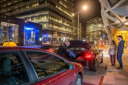 Taxi driver loading passenger luggage