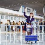 The woman on the airport with the lagguage trolley
