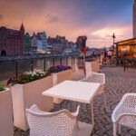 Old town in Gdansk with historical port crane over Motlawa river at rainy sunset, Poland.