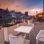 Old town in Gdansk with historical port crane over Motlawa river at rainy sunset, Poland.