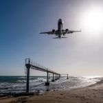Plane lands almost at airport Lanzarote, seen from beach towards the sea