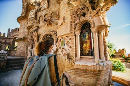 Young woman photographing the ornate Spanish architecture of Castillo de Colomares Benalmadena