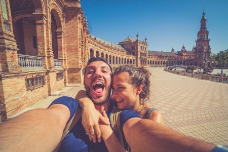 happy smiling couple take photo selfie in Spain square (plaza de espana) in Sevilla, Spain