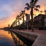 Beautiful port of Alicante, Spain at Mediterranean sea. Luxury yachts, ships, ferries and fishing boats sailing and standing in rows in harbor.