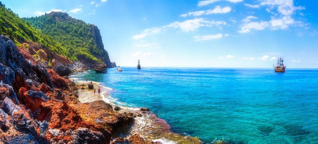 Beautiful seascape in Alanya, Turkey. Sunny summer day in turkey resort. Amazing view on rocky coastline and blue mediterranean sea with ships.