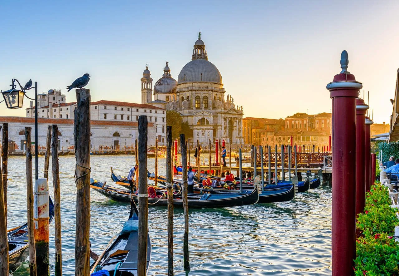 Canal Grande with Venice gondola and Basilica di Santa Maria della Salute in Venice at sunset, Italy. Architecture and landmarks of Venice. Venice postcard