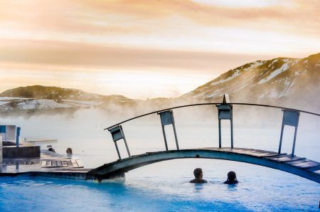 Couple under the bridge in the thermal blue lagoon, Iceland