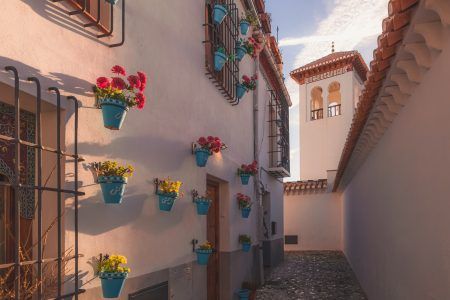 Early morning golden light over the quiet and quaint narrow cobblestone streets in old town (Albaicin or Arab Quarter) Granada