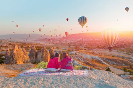 Hot Air Balloon Flying Over Spectacular Cappadocia – Girls viewing a balloon on Cappadocia hill