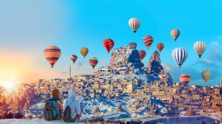 Hot air balloon flying over spectacular Cappadocia – Girls watching hot air balloon at the hill of Cappadocia