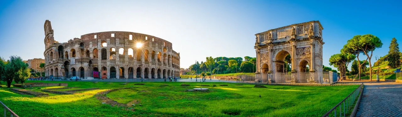 Panorama of Colosseum and Constantine arch at sunrise in Rome, Italy