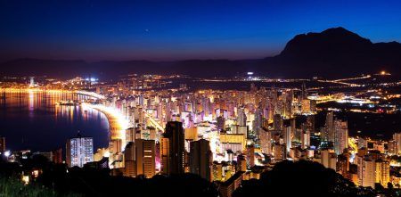 Panorama of the city and the sea coast at sunset on a background of mountains (Spain, Benidorm)