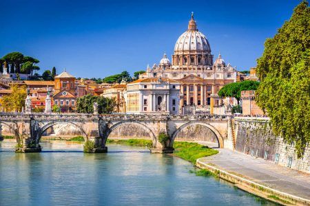 Rome, Italy. Vatican dome of St. Peter’s Basilica (Italian San Pietro) and Sant’Angelo Bridge, on the Tiber River.