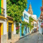 Scenic sight in the picturesque Cordoba jewish quarter with the bell tower of the Mosque Cathedral.
