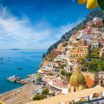 Aerial view of Positano with comfortable beach and blue sea on Amalfi Coast in Campania, Italy. Amalfi coast is popular travel and holyday destination in Europe. Ripe yellow lemons in foreground