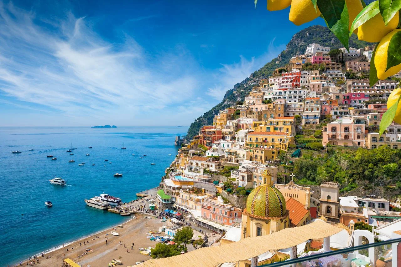 Aerial view of Positano with comfortable beach and blue sea on Amalfi Coast in Campania, Italy. Amalfi coast is popular travel and holyday destination in Europe. Ripe yellow lemons in foreground