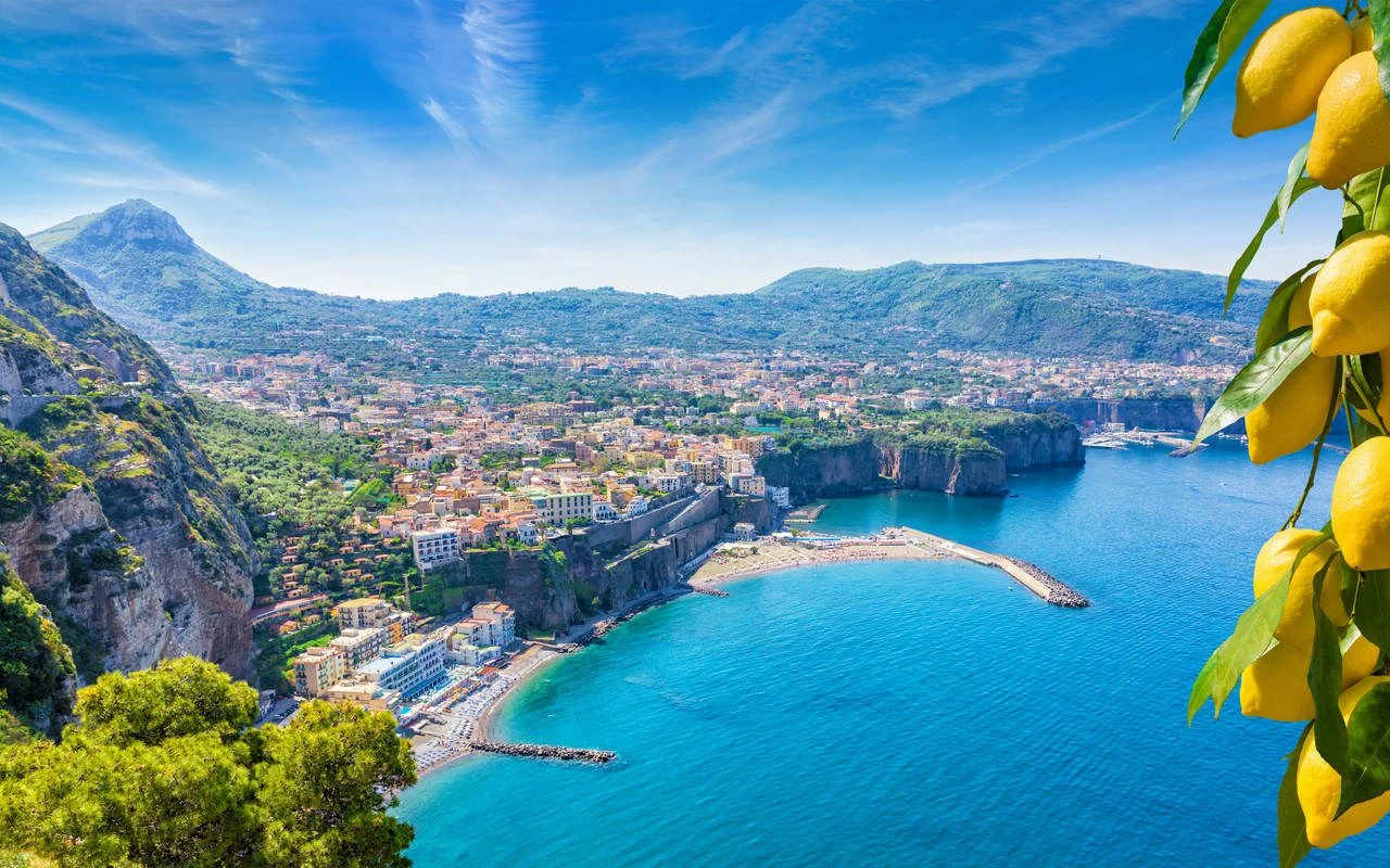 Aerial view of cliff coastline Sorrento and Gulf of Naples, Italy. Ripe yellow lemons in foreground. In Sorrento lemons are used in production of limoncello