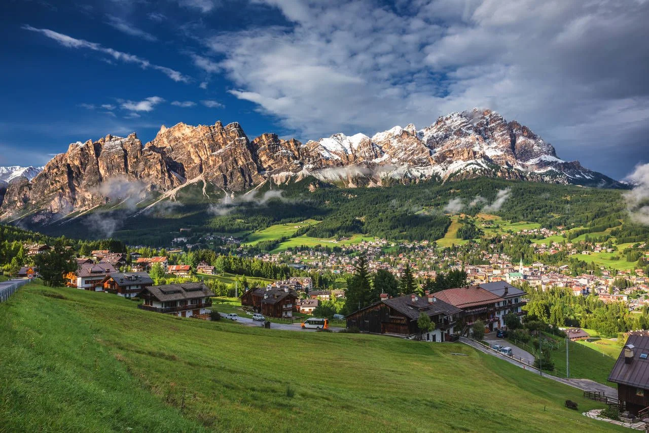 Cortina d’Ampezzo town panoramic view with alpine green landscape and massive Dolomites Alps in the background. Province of Belluno, South Tyrol, Italy.