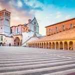 Famous Basilica of St. Francis of Assisi (Basilica Papale di San Francesco) with Lower Plaza at sunset in Assisi, Umbria, Italy