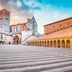 Famous Basilica of St. Francis of Assisi (Basilica Papale di San Francesco) with Lower Plaza at sunset in Assisi, Umbria, Italy