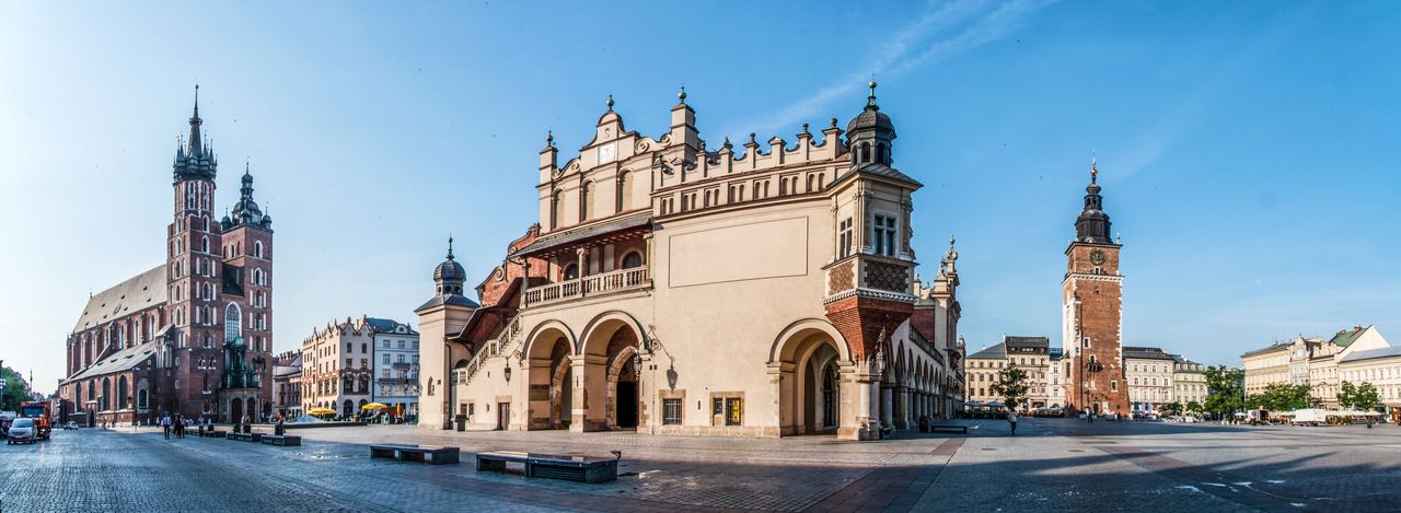 A panoramic photo of the Main Square in Krakow, Poland: St Mary's Basilica, Sukiennice Cloth Hall, Town Hall Tower