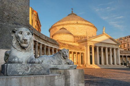 Naples, Italy, view of Basilica Reale Pontificia San Francesco da Paola church on Piazza del Plebiscito, main square of the city, and stone lion sculptures on sunrise