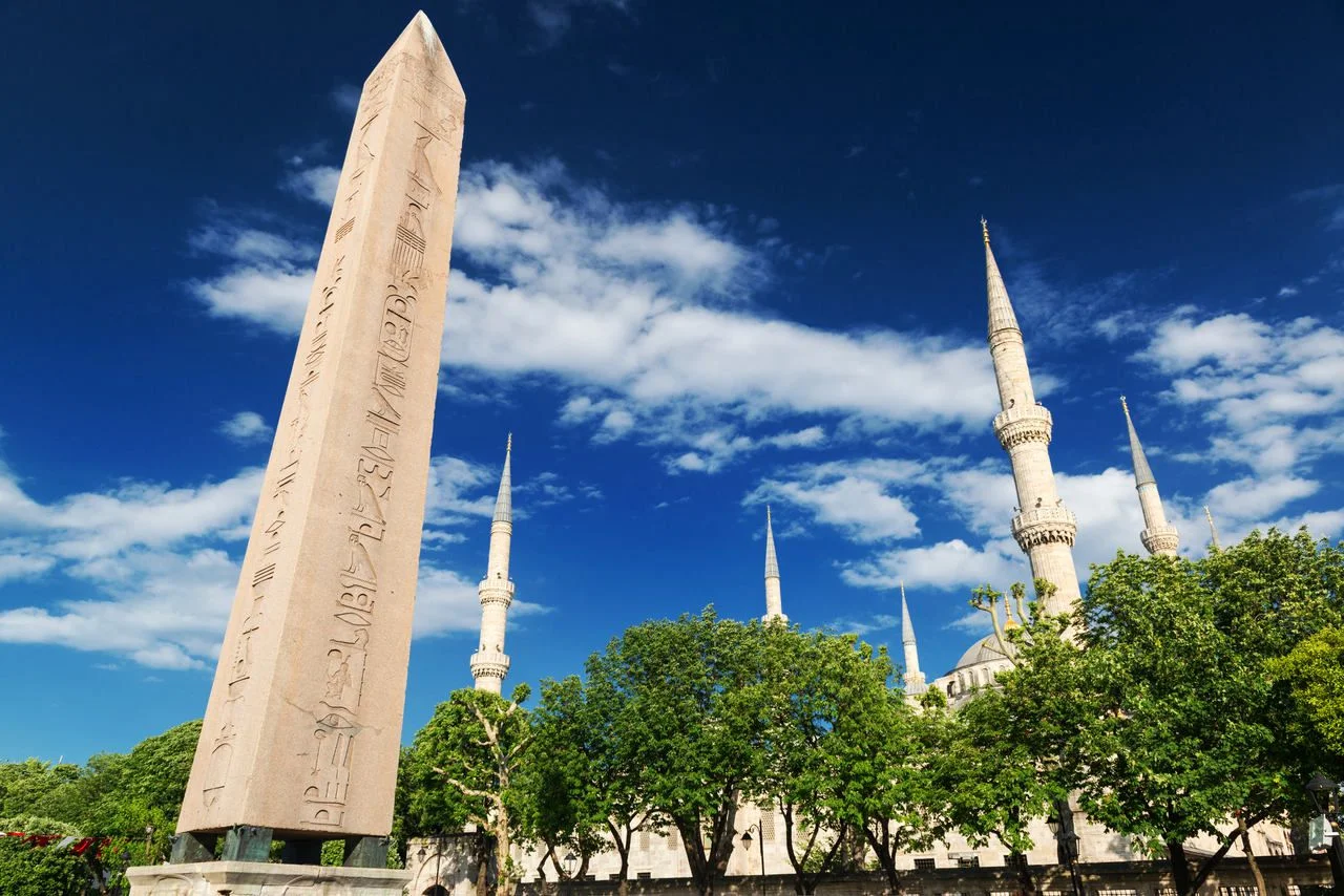 Obelisk of Theodosius on the former Roman Hippodrome, Istanbul, Turkey. Hippodrome of Constantinople city in summer. It is the Sultanahmet square in Istanbul today. Cityscape of Istanbul with mosque.
