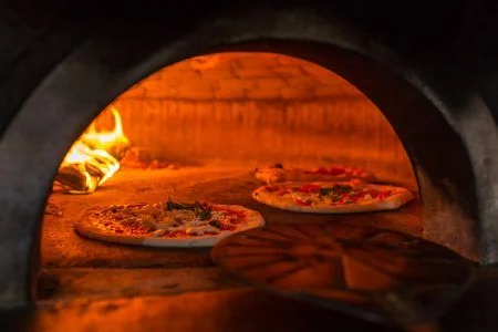 Original Neapolitan margherita pizza in a traditional wood oven in a restaurant Naples, Italy