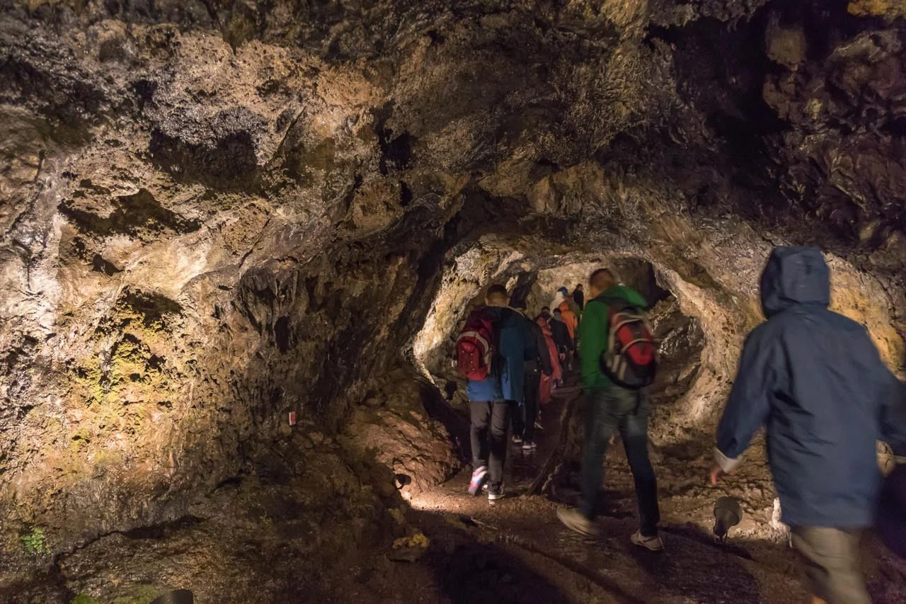 People walking in Sao Vicente Volcanic Lava Caves of Madeira formed 890 thousand years ago by a volcanic eruption, an underground route running for over 1,000 m, the height varies between 5 and 6 m.