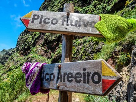 Signboard on the touristic trail Pico Ruivo- Pico Areeiro with two warm hats on it. Madeira. Portugal.