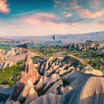 The unreal world of Cappadocia. A colorful sunrise in the Red Rose Valley in April. Cavusin is a village located in Nevsehir Province in the Cappadocia region of Turkey, Asia.
