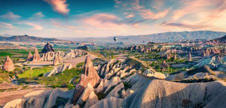 The unreal world of Cappadocia. A colorful sunrise in the Red Rose Valley in April. Cavusin is a village located in Nevsehir Province in the Cappadocia region of Turkey, Asia.