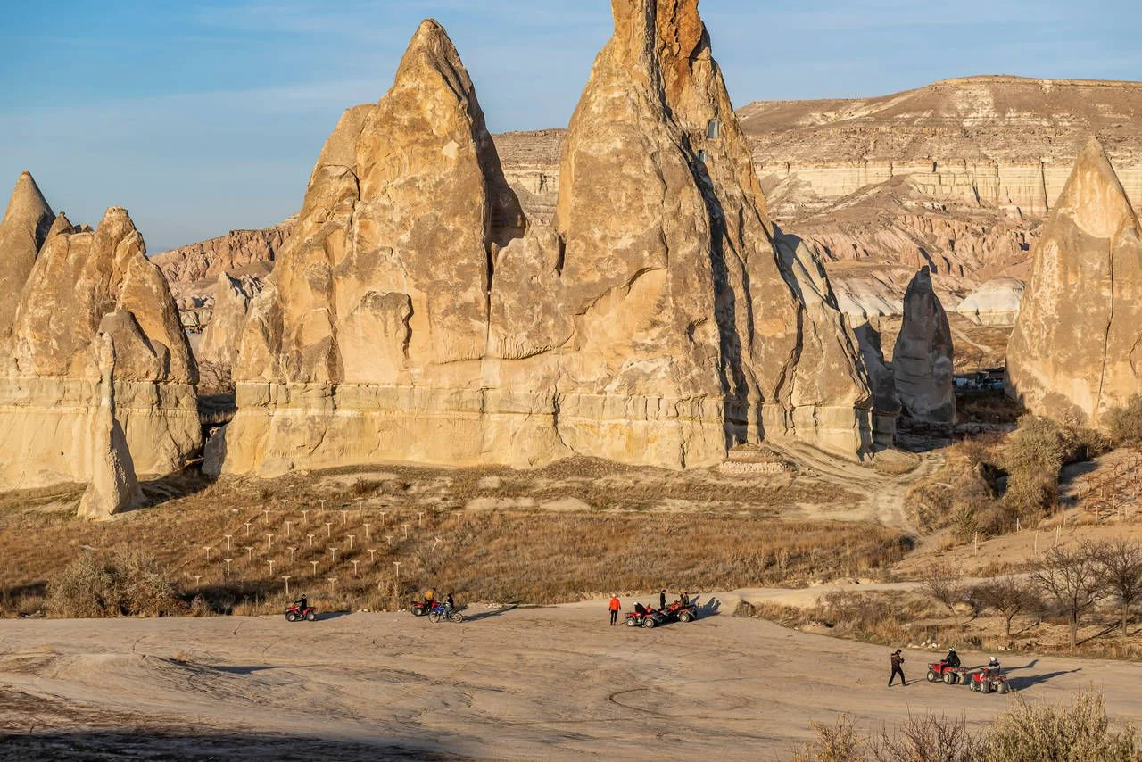 Tourists on safari in Cappadocia with ATV vehicles with views of beautiful fairy chimneys and vineyards