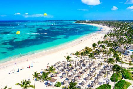 Aerial view of Bavaro beach Punta Cana tropical resort in Dominican Republic. Beautiful atlantic tropical beach with palms, umbrellas and parasailing balloons