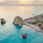 Aerial view of Petra tou Romiou, aka Aphrodite rock famous tourist travel landmark in Paphos, Cyprus. Sea bay goddess Afroditi birthplace at sunset from above.