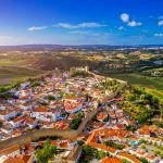 Aerial view of the historic walled town of Obidos at sunset, near Lisbon, Portugal. Aerial shot of Obidos Medieval Town, Portugal. Aerial view of medieval fortress in Obidos. Portugal.