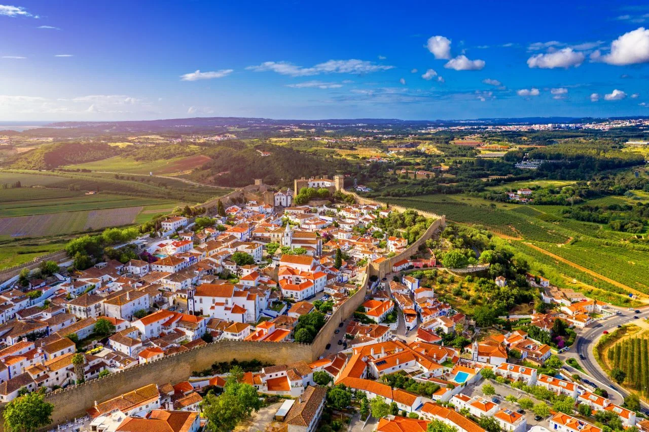Aerial view of the historic walled town of Obidos at sunset, near Lisbon, Portugal. Aerial shot of Obidos Medieval Town, Portugal. Aerial view of medieval fortress in Obidos. Portugal.