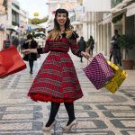 Cute and happy pinup girl goes shopping in Christmas on the streets of Faro, Portugal