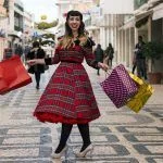 Cute and happy pinup girl goes shopping in Christmas on the streets of Faro, Portugal