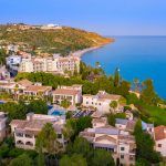 Island of Cyprus. The Village Of Pissouri. Tourist area on the Mediterranean coast. The view from the top of the resort of Pissouri. Holidays in Cyprus. Hotels, trees and the Mediterranean sea