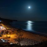 Night beach of the village of Salema, with the moon over the sea. Portugal