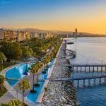 Sunset in Cyprus. The sun sets in the Mediterranean. Limassol at sunset. Evening panorama of Limassol with height. Mediterranean evening landscape. Holidays in Cyprus.