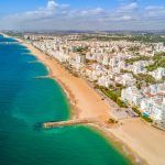 Wide sandy beach in touristic resorts of Quarteira and Vilamoura, Algarve, Portugal