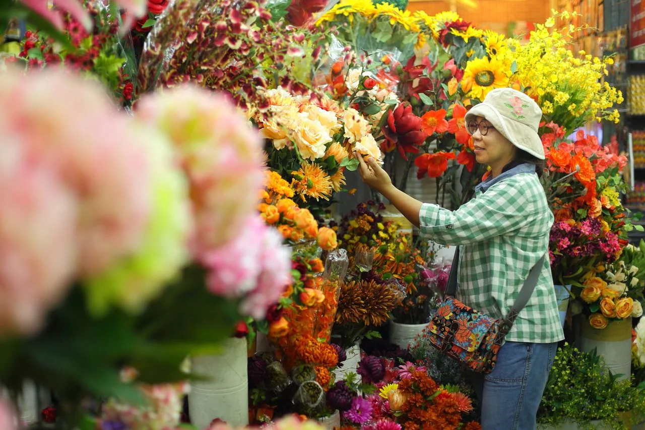 Asian woman shopping flowers at JJ market. JJ market is landmark of bangkok. Selective focus.
