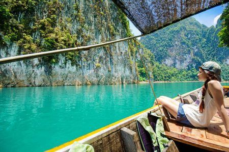 Asian women seeing the beautiful view of Ratchaprapha Dam ,khao sok national park,surat thani ,thailand on her vacation time