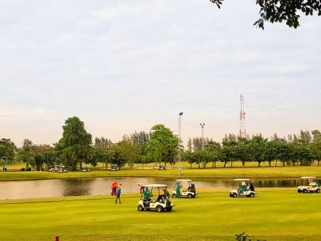 Bangkok ,Thailand – Nov 29’2018 Golf field at Bangkok Golf Club, Golfers playing on beautiful fairway. Golf is popular sport. Blue sky, lake and trees on the layout yard.