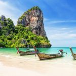Thai traditional wooden longtail boat and beautiful sand Railay Beach in Krabi province. Ao Nang, Thailand.