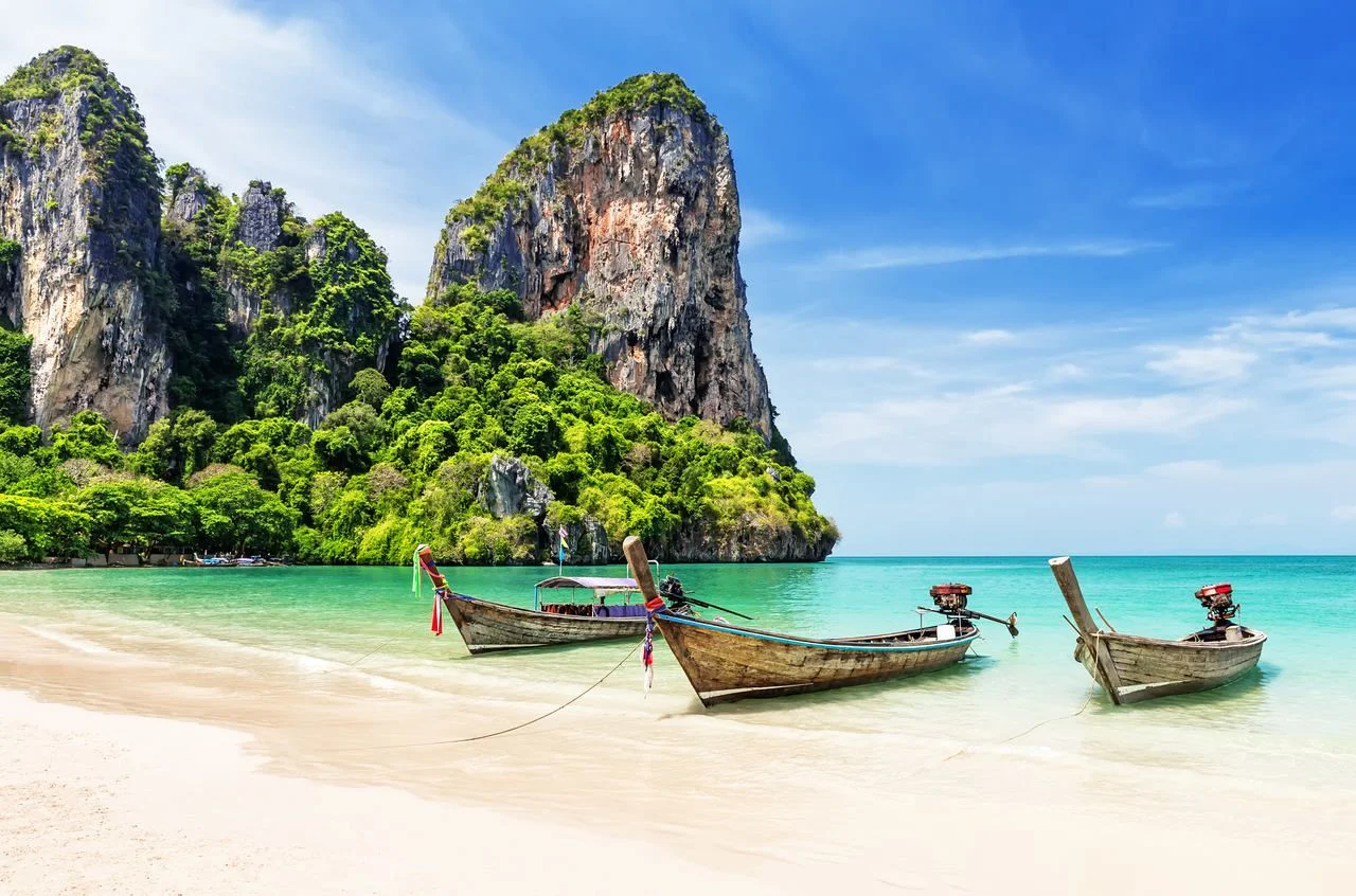 Thai traditional wooden longtail boat and beautiful sand Railay Beach in Krabi province. Ao Nang, Thailand.
